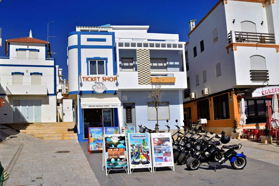 Ticket shop with display boards and parked scooters