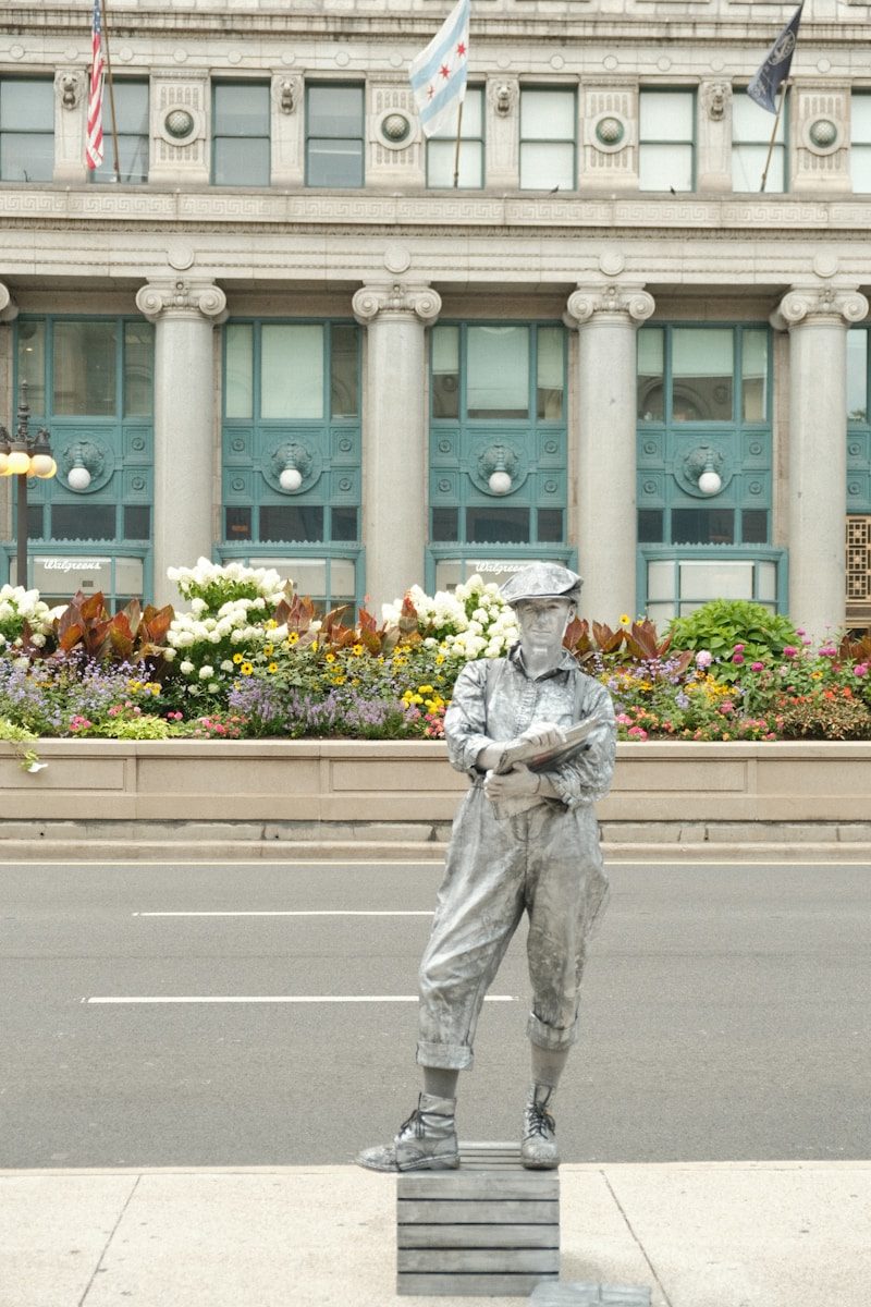man in gray jacket and pants holding bouquet of flowers standing on gray concrete road during