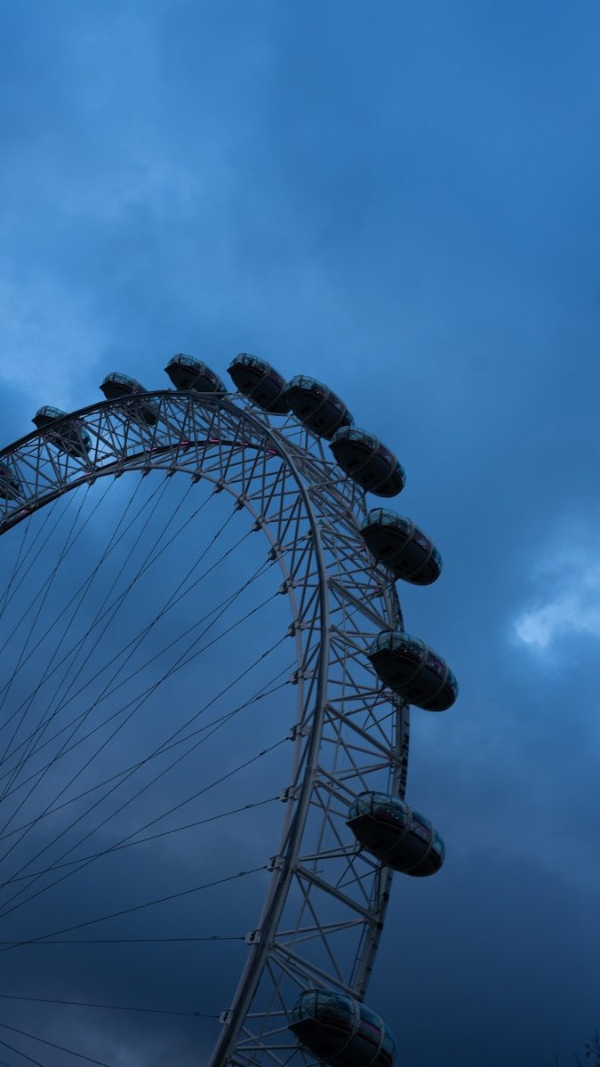 a large ferris wheel sitting under a cloudy blue sky