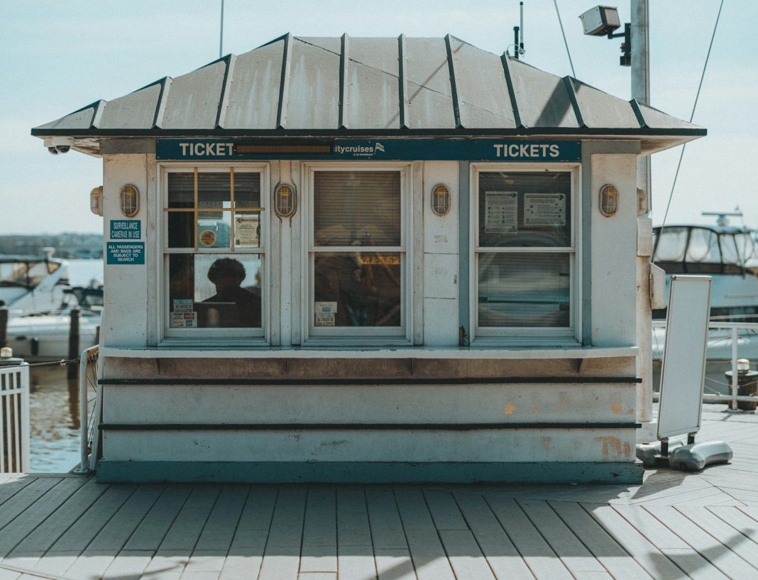 A small ticket booth with a person inside.