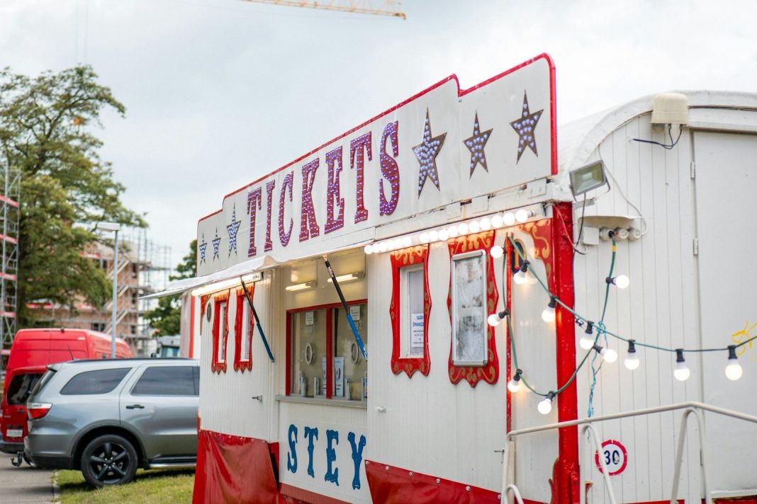 A ticket booth at a carnival with string lights